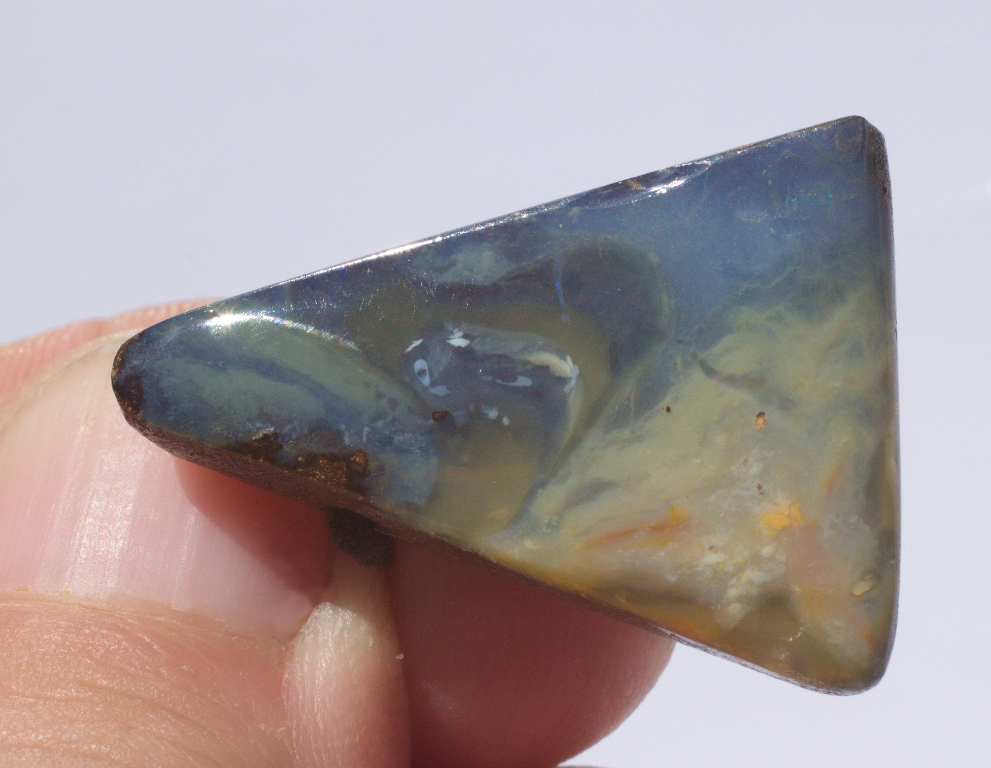 Boulderopal als Dreieck geschliffen, seitliche Bohrung mit Lederband  