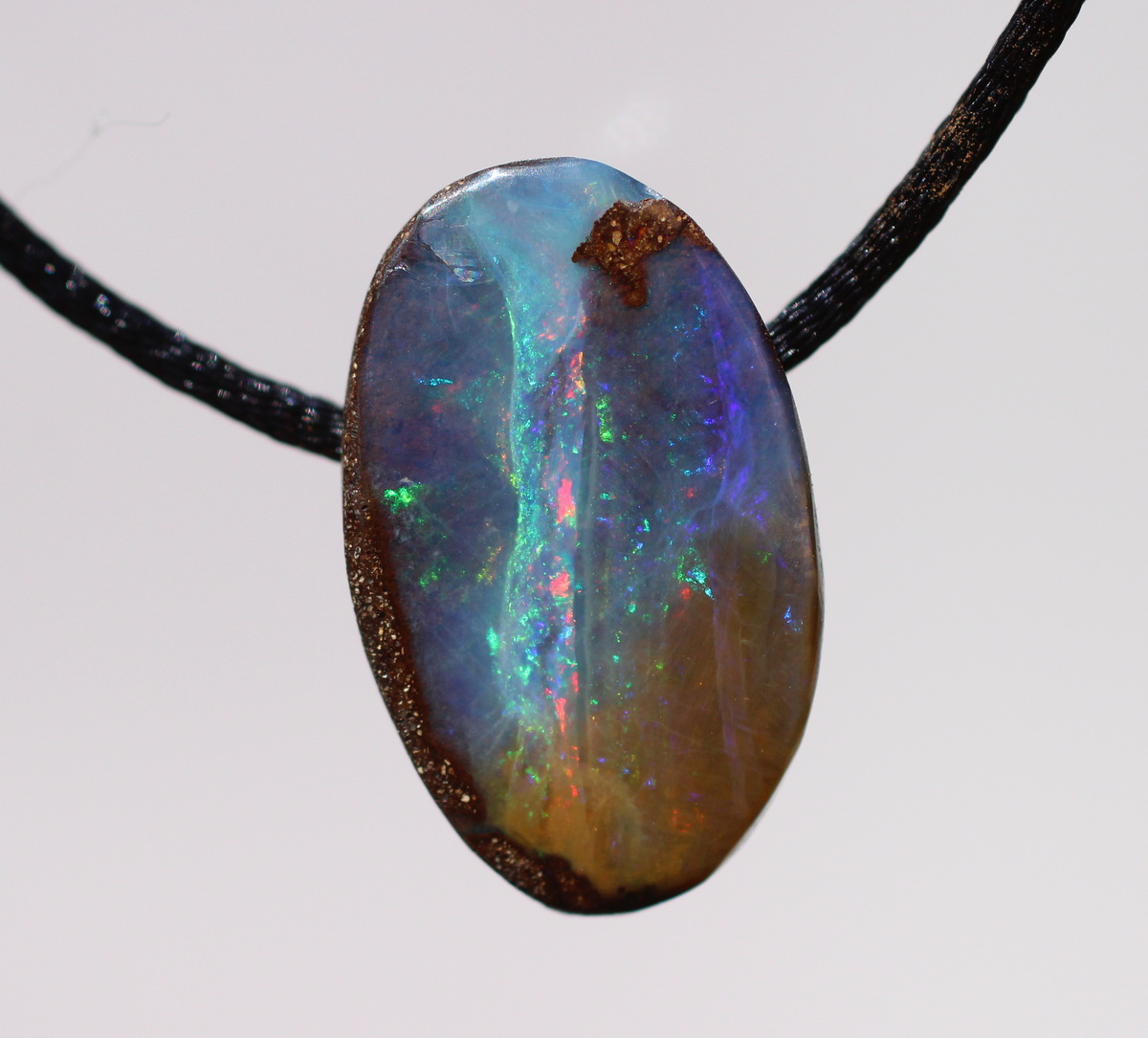 Kleiner ovaler Boulderopal, seitlich gebohrt mit Lederband 