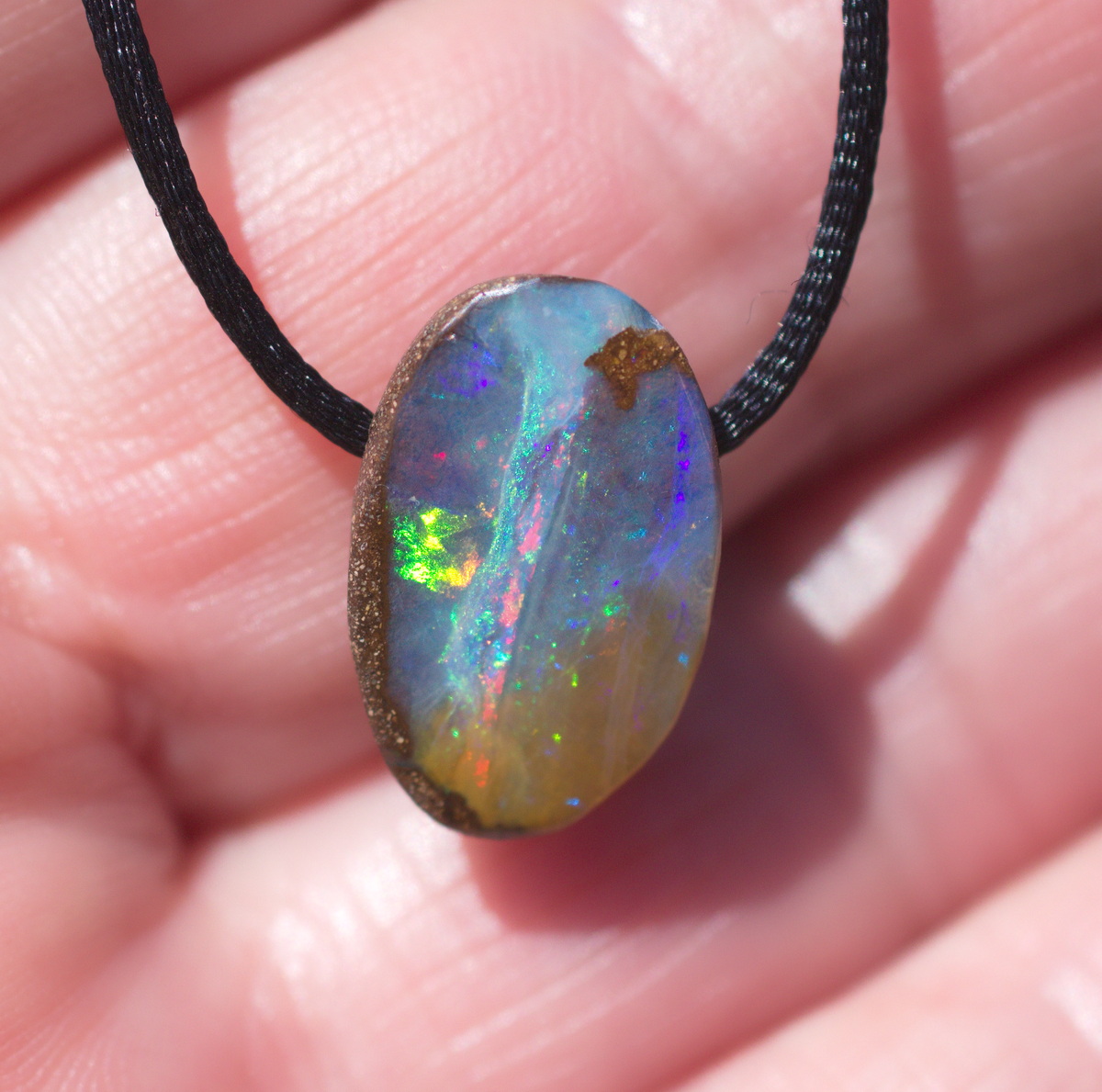 Kleiner ovaler Boulderopal, seitlich gebohrt mit Lederband 