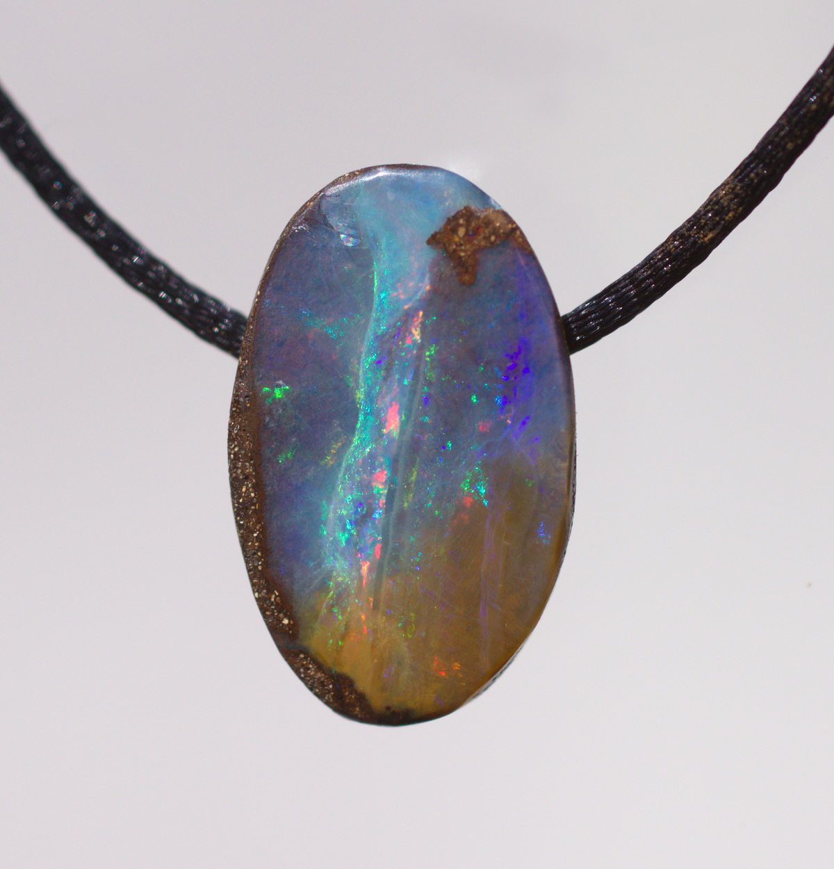 Kleiner ovaler Boulderopal, seitlich gebohrt mit Lederband 