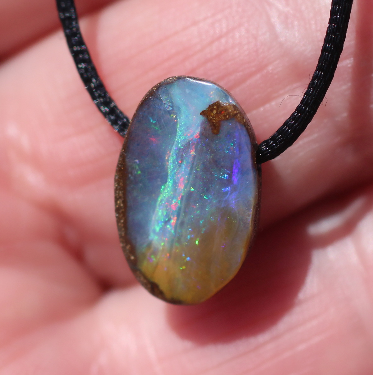 Kleiner ovaler Boulderopal, seitlich gebohrt mit Lederband 