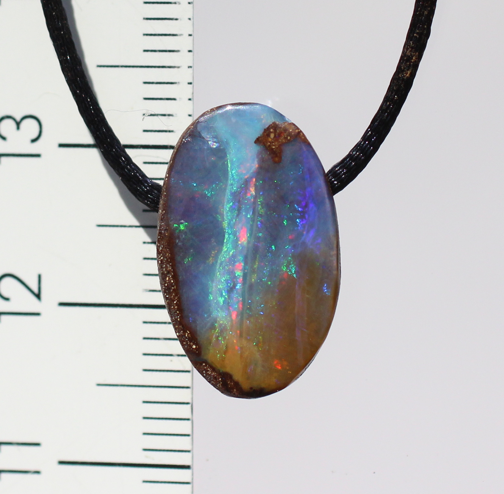 Kleiner ovaler Boulderopal, seitlich gebohrt mit Lederband 